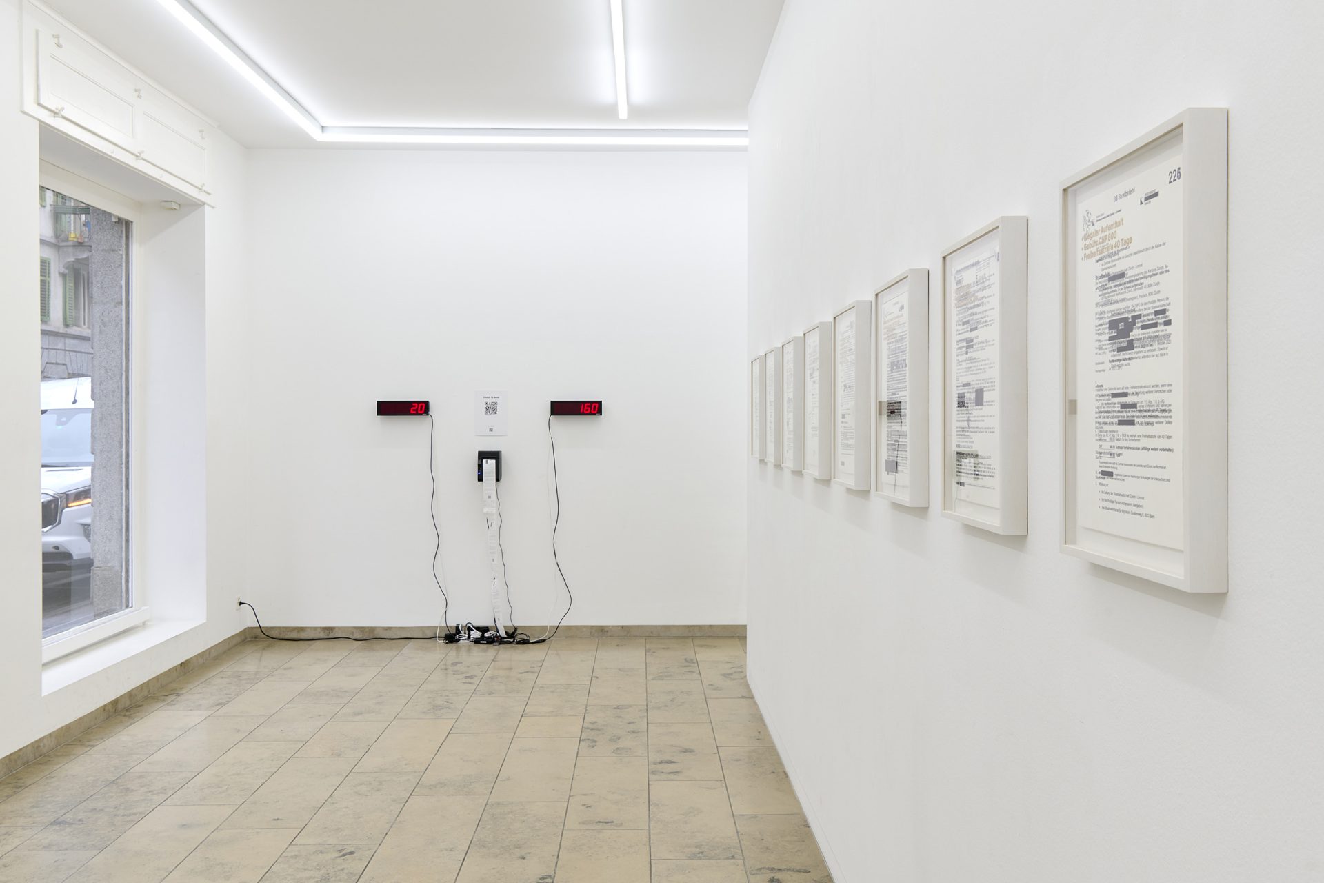 Two LED displays and a receipt printer in a gallery, showing donations and how much money can be saved with them. 